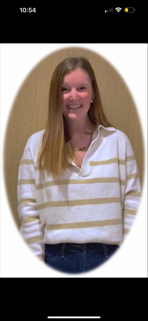 Woman with blonde hair, wearing a striped shirt, smiling.